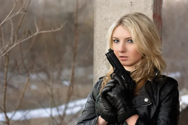 Jeune femme effrayée avec une arme — Photo