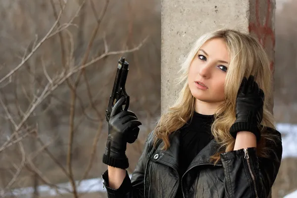 Förvirrad blondin tjej med en pistol — Stockfoto