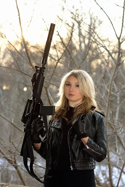 Frightened young woman with a rifle — Stock Photo, Image