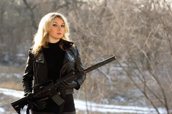 Aantrekkelijke jonge blonde met een pistool — Stockfoto