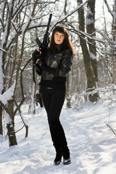 Woman with a rifle in winter forest — Stock Photo, Image