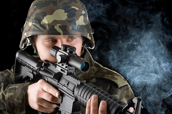 Soldat mit der rauchenden Waffe. Nahaufnahme — Stockfoto