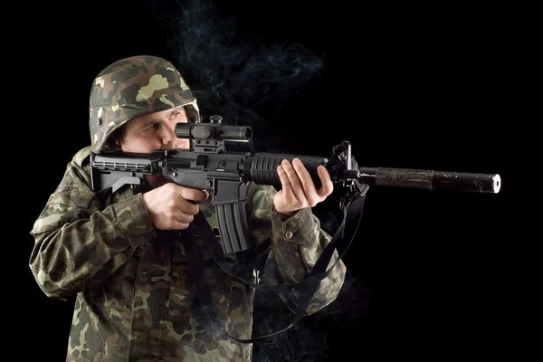 Άγρυπνος στρατιώτης που κρατά ένα όπλο που καπνίζει — Φωτογραφία Αρχείου