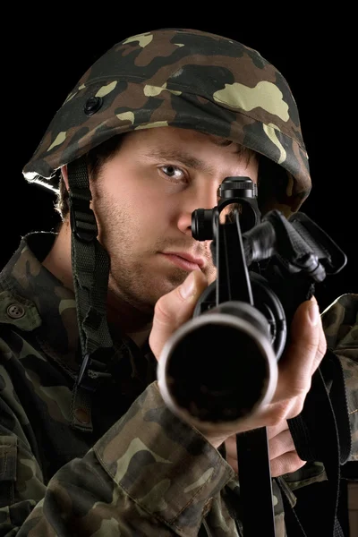 Ready soldier aiming a rifle in studio — Stock Photo, Image