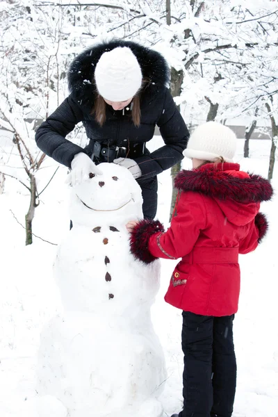 Děti stavět sněhuláka — Stock fotografie