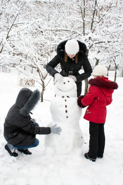 Діти будують сніговика — стокове фото