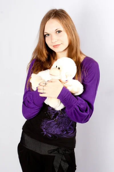 Beautiful young woman with a toy a monkey — Stock Photo, Image