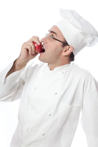 Cook eating red apple — Stock Photo, Image