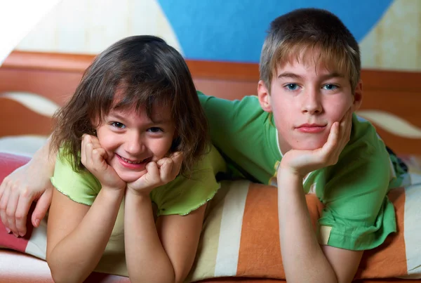 Children lying on their bellies in a bedroom — Stock Photo, Image