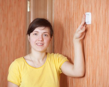 Woman turning off the light switch clipart