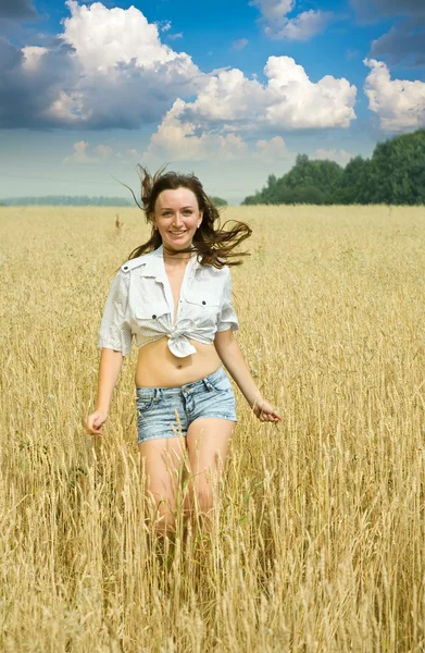 Бегущая девушка на пшеничном поле — стоковое фото