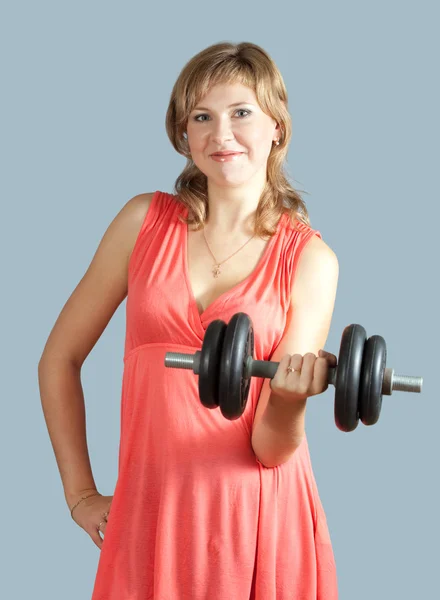 Woman in dress with barbell — Stock Photo, Image