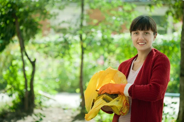 Agricoltore femminile fertilizza il terreno in giardino — Foto Stock