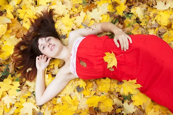 Woman lies in maple leaves — Stock Photo, Image