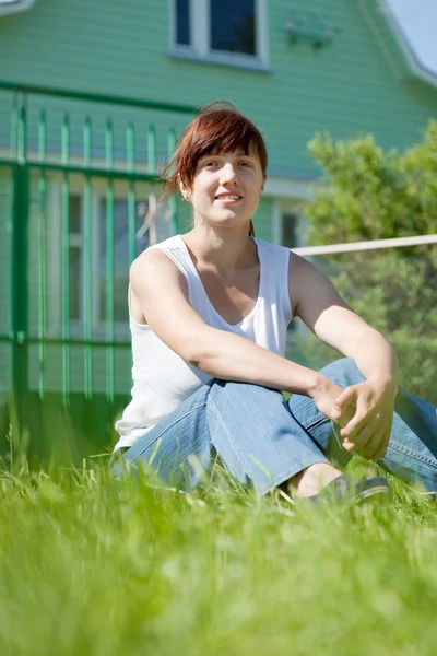 Happy woman on lawn in front of home — Stock Photo, Image