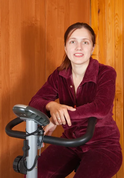 Mulher se exercitando em bicicleta de exercício — Fotografia de Stock