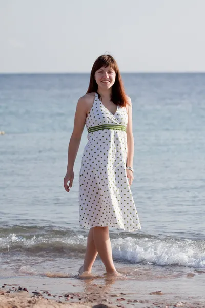 Vrouw lopen op zee strand — Stockfoto