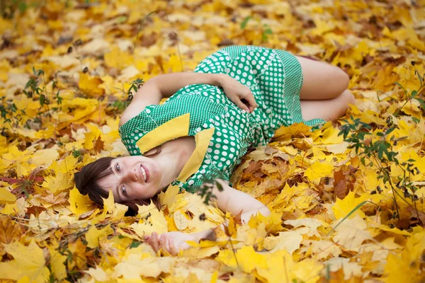Girl lies in autumn park — Stock Photo, Image
