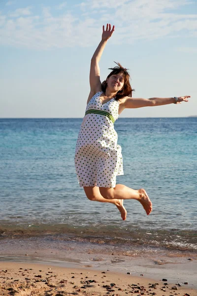 Žena skáče na mořské pláži — Stock fotografie