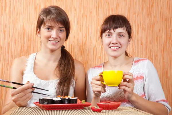 Mulheres comendo rolos de sushi — Fotografia de Stock