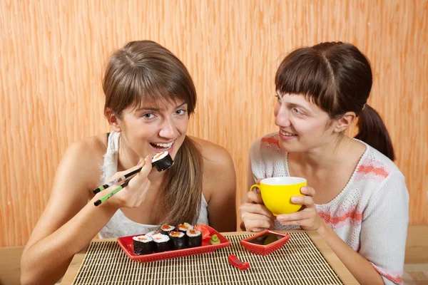 Glada kvinnor äter sushi rullar — Stockfoto