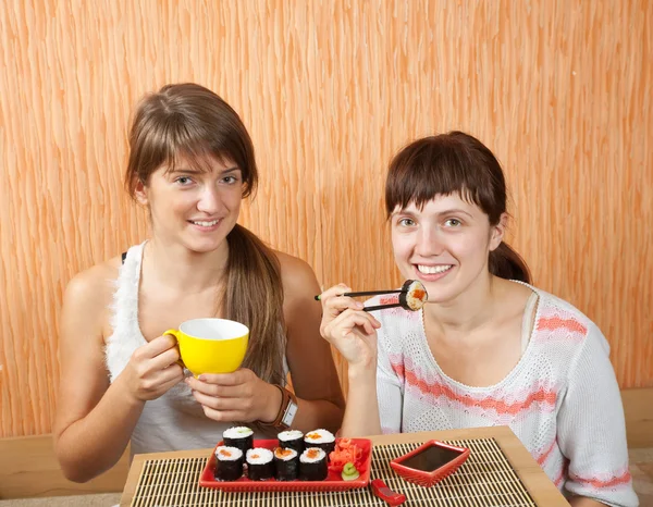 Två kvinnor äter sushi rullar — Stockfoto