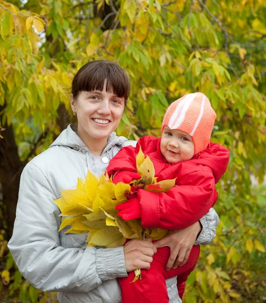 Happy mother with baby in autumn — Stok fotoğraf