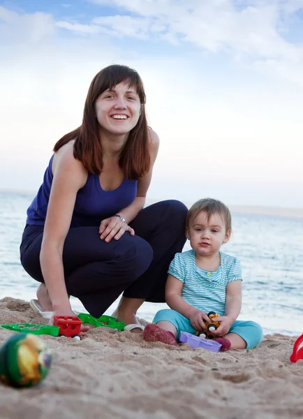 Mãe feliz com a criança na praia — Fotografia de Stock