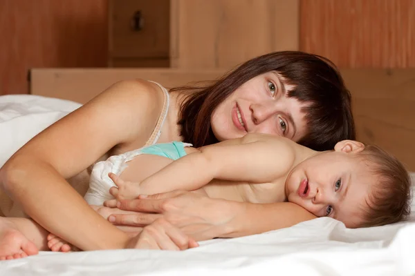 Mother with her baby on white sheet — Stock Photo, Image