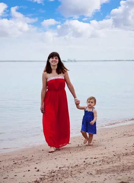 Kum plajı üzerinde yürüme yürümeye başlayan çocuk ile anne — Stok fotoğraf