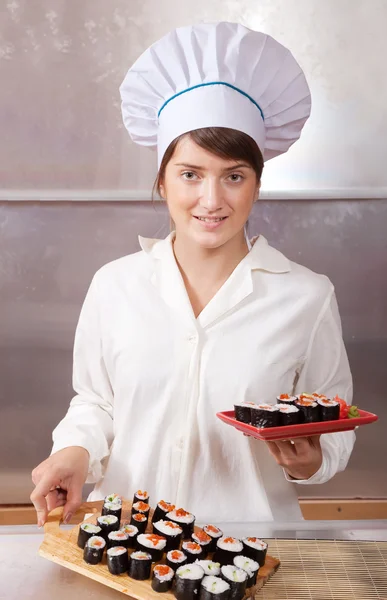 stock image Cook woman with cooked sushi rolls