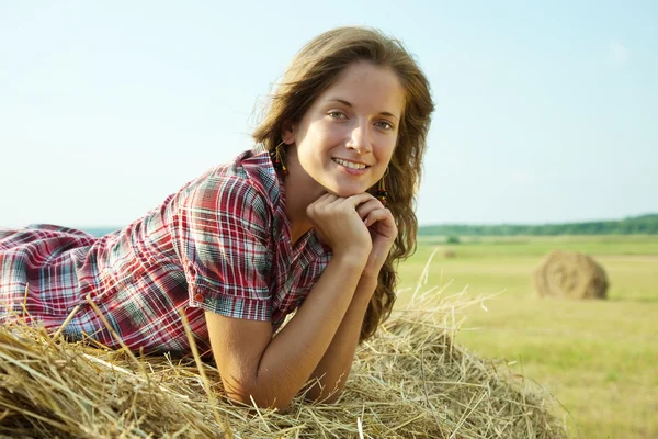 Pretty girl on straw bale — Stock Photo, Image