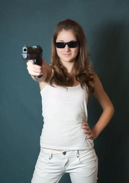 Ragazza in occhiali da sole puntando una pistola — Foto Stock