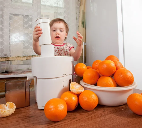 Baby girl making fresh orange juice — Stock Photo, Image