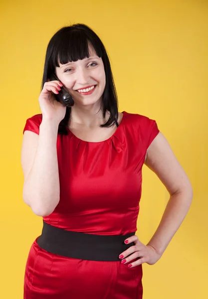 Mujer en rojo habla por teléfono sobre amarillo — Foto de Stock