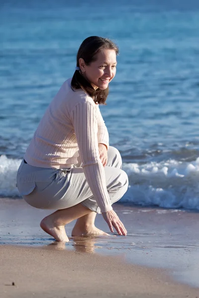 Glad mogen kvinna på strand — Stockfoto
