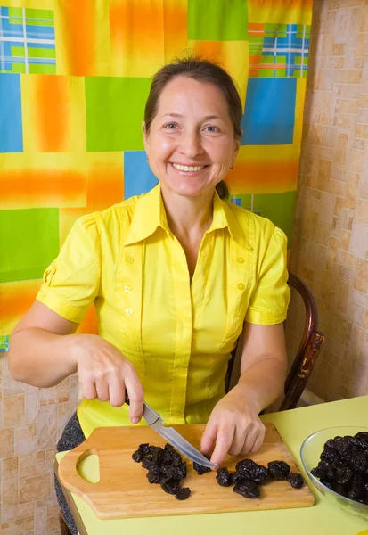 Женщина режет чернослив — стоковое фото