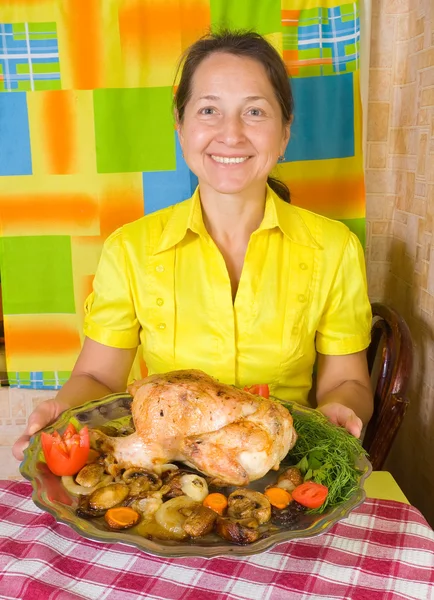 Γυναίκα με μαγειρεμένο ψημένο κοτόπουλο — Φωτογραφία Αρχείου