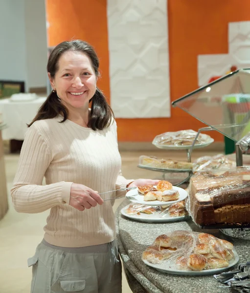 Vrouw neemt vers gebak — Stockfoto