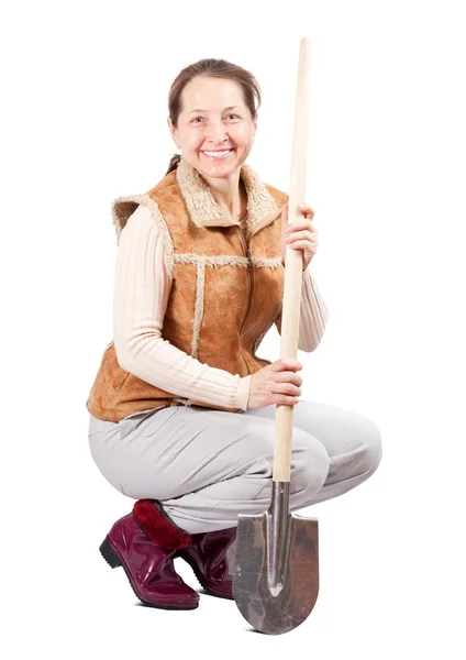 Woman sits with spade over white — Stock Photo, Image