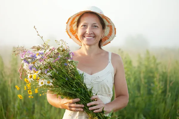 Femme mûre avec bouquet de fleurs — Photo