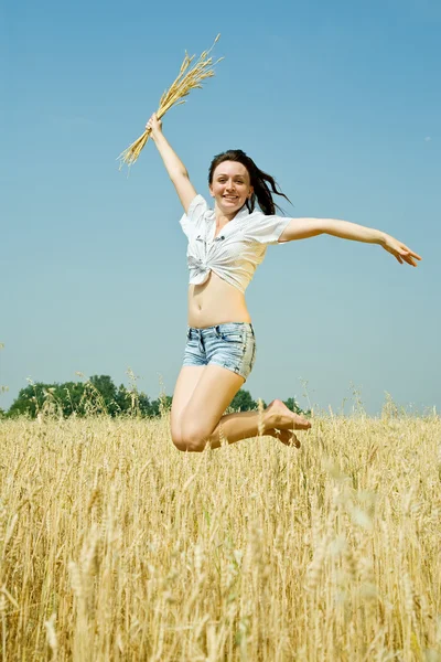 Прыгающая девушка в поле — стоковое фото