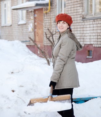 Girl throwing snow with shovel clipart