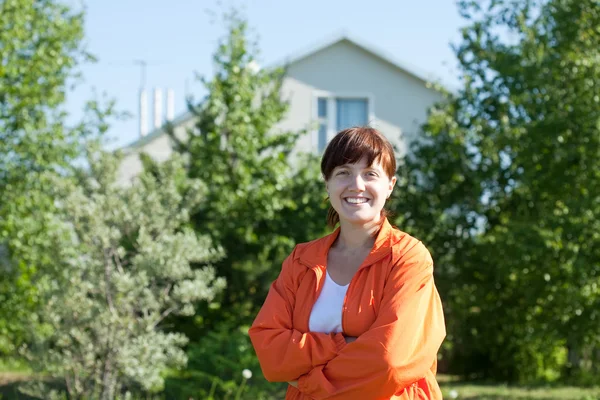 Happy woman posing in front of residence — Stock Photo, Image