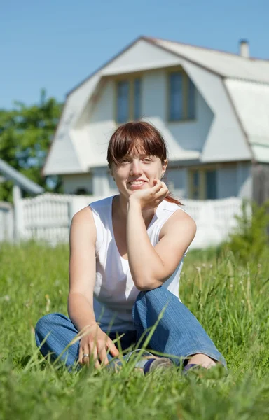 Happy woman on lawn in front of home — Stock Photo, Image