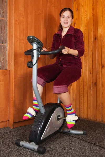 Kobieta ćwiczenia na rower treningowy — Zdjęcie stockowe