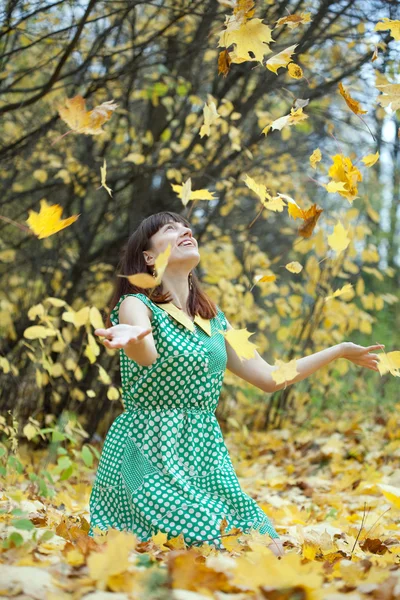 Девушка бросает кленовые листья в воздух — стоковое фото