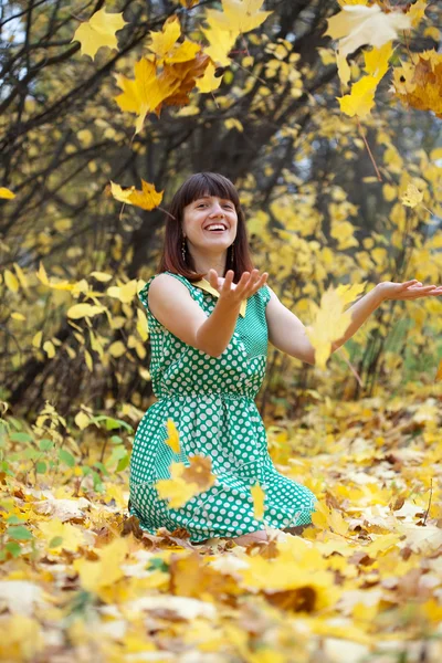 Девушка бросает листья в воздух — стоковое фото