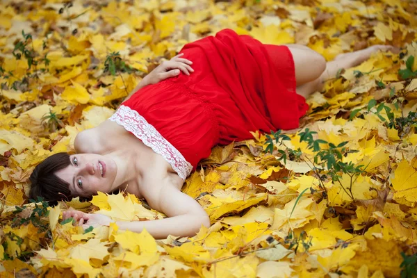 Kız akçaağaç yaprakları içinde yer alır. — Stok fotoğraf
