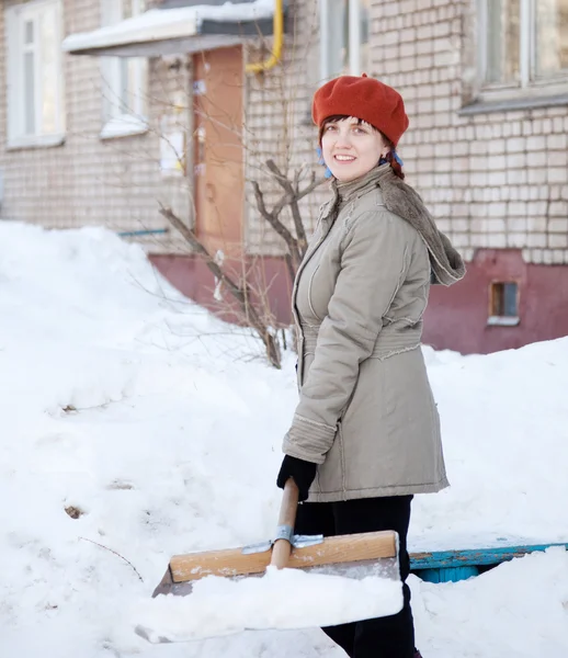 Девушка бросает снег с лопатой — стоковое фото
